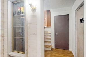 Un escalier menant à une porte sur laquelle est apposée une plaque indiquant le numéro de la chambre : 119.