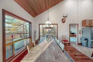 Un comedor amplio con una mesa larga, ventanas grandes y vistas al exterior.
