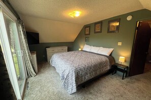 A bedroom with a bed, a nightstand, a dresser, and a window with curtains. - Hodges Hill Yosemite House (Oakhurst)