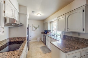 A kitchen with white cabinetry, a stainless steel range hood, a built-in stovetop, and a granite countertop. - Putney Place - Hot Tub & Mountain Views (North Fork)
