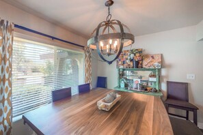 A dining area with a wooden table, a chandelier, and a glass display cabinet. - Putney Place - Hot Tub & Mountain Views (North Fork)