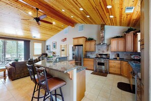 A spacious kitchen with a large island, wooden cabinets, and a ceiling fan. - Murray Lake Retreat - Near Bass Lake, Fireplace (Bass Lake)