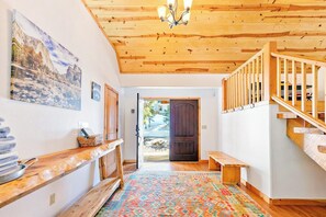A wooden interior with a patterned rug, a wooden bench, and a staircase. - Oso Lodge - Ping-Pong, Deck & EV Charger (Yosemite West)