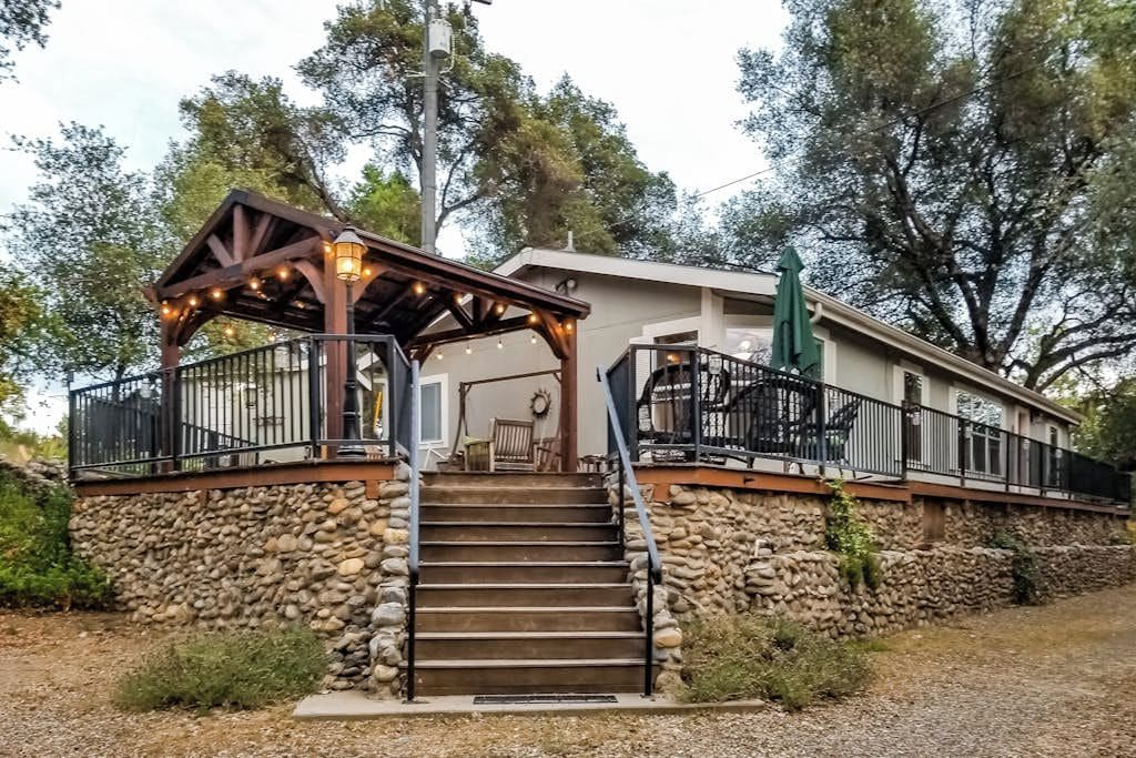 A stone staircase leading to a wooden covered porch with outdoor seating.