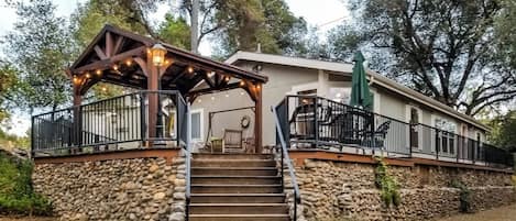 A stone staircase leading to a wooden covered porch with outdoor seating.