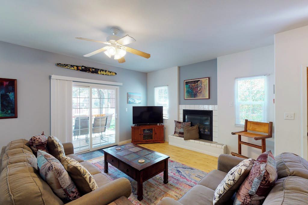 A living room with a sofa, a coffee table, a television, and a fireplace.