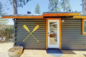 Eine Holzhütte mit einer Veranda und einem an der Wand angelehnten Paddel.