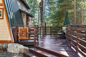 A wooden deck leading to a cabin with a sign reading 'Life is better at Chief Peak Cabin.' - Chief Peak Cabin - Near Yosemite, Deck & Loft (Fish Camp)