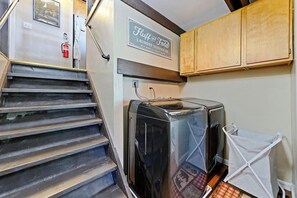 A laundry room with a sign reading 'Fluff and Fold Laundry Service Co.' and a dryer. - Chief Peak Cabin - Near Yosemite, Deck & Loft (Fish Camp)