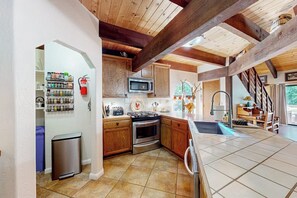 A kitchen with wooden cabinets, a microwave, and a sink. - Wishing Well Cabin - Near Yosemite & Bass Lake (Bass Lake)