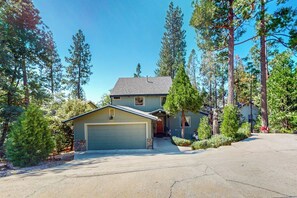 A two-story house with a garage, surrounded by tall pine trees. - Wishing Well Cabin - Near Yosemite & Bass Lake (Bass Lake)