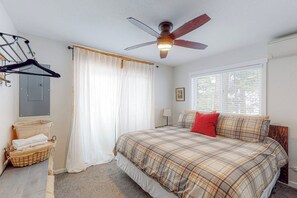 A bedroom with a bed, a ceiling fan, a window with blinds, a wall-mounted heater, and a basket with towels. - Starfall - Modern Yosemite Home, Great Deck (Yosemite West)