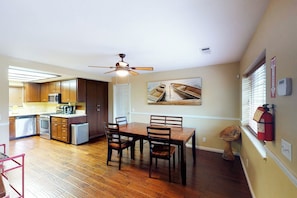 A spacious kitchen with wooden cabinets, a dining table with chairs, and a ceiling fan. - Calandri Lakeview House (Bass Lake)
