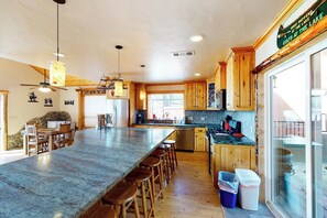 Una cocina amplia con una isla grande, armarios de madera y vista al lago.