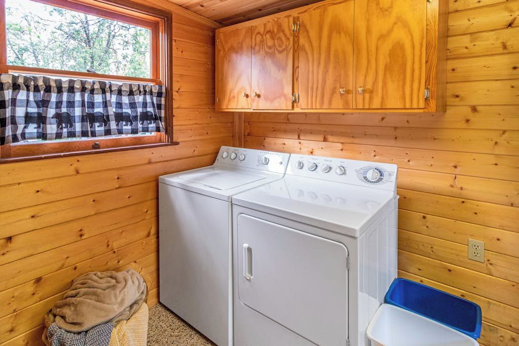 Una cucina compatta con lavatrice, asciugatrice e mobili in legno.
