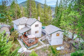 A two-story house with a deck and a covered patio area. - Black Bear Cabin - Boat Slip, Walk to Lake (Bass Lake)