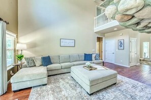 A spacious living room with a sectional sofa, ottoman, and a large rug. - Wooded Bliss - Near Yosemite, Sweeping Views (Mariposa)