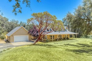 A single-story house with a garage, a covered porch, and a well-maintained lawn. - Wooded Bliss - Near Yosemite, Sweeping Views (Mariposa)