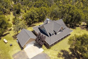A two-story house with a large garage, surrounded by trees. - Wooded Bliss - Near Yosemite, Sweeping Views (Mariposa)