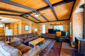 A log cabin interior with a living room, sofa, television, and fireplace. - Yosemite Big Rock Cabin (Fish Camp)