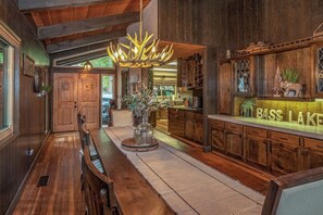 Ein Holzinterieur mit Barbereich, einem Kronleuchter und einem Schild mit der Aufschrift 'BASS LAKE'.
