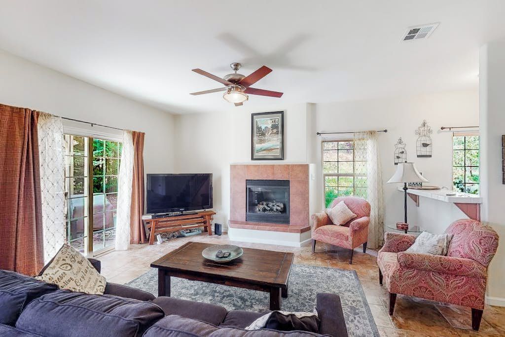 Una sala de estar con chimenea, televisor y dos sillones.