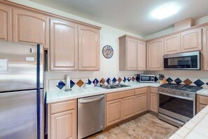 A kitchen with wooden cabinets, stainless steel appliances, a microwave, and a dishwasher. - Willard Lake House - Heated Pool, Hot Tub & Views (Bass Lake)