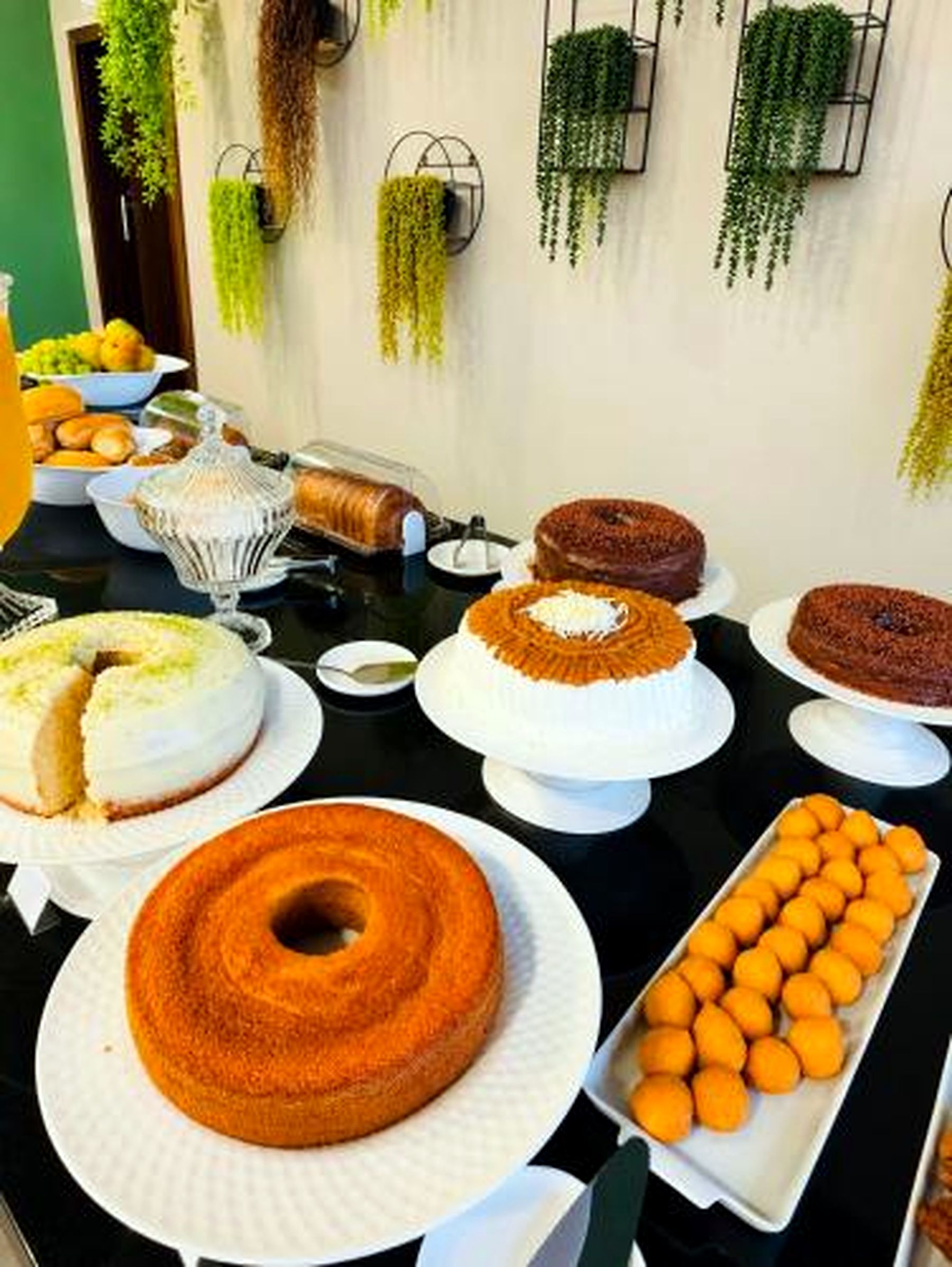 A buffet table with various cakes and pastries.