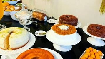A buffet table with various cakes and pastries.