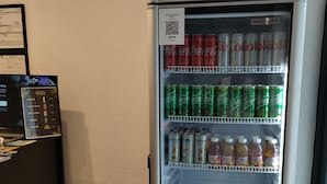 Una máquina expendedora con diversas bebidas, incluyendo Coca-Cola, Sprite y Welch's.