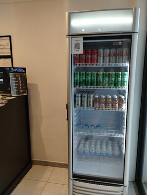 En försäljningsautomat med ett urval av drycker, inklusive Coca-Cola, Sprite och Welch's.