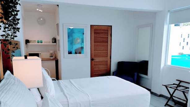 Habitación de hotel con dos camas, un escritorio con silla, televisión y ventana con vistas.