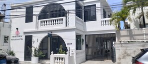 A two-story white building with a sign reading "TRINITARIA HOUSE HOTEL". - Suite 7 at Trinitaria House Hotel (San Juan)