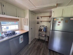 A compact kitchen with a refrigerator, a sink, and a window. - Those Southern Nights can be memorable in Fort Gaines, GA (Fort Gaines)