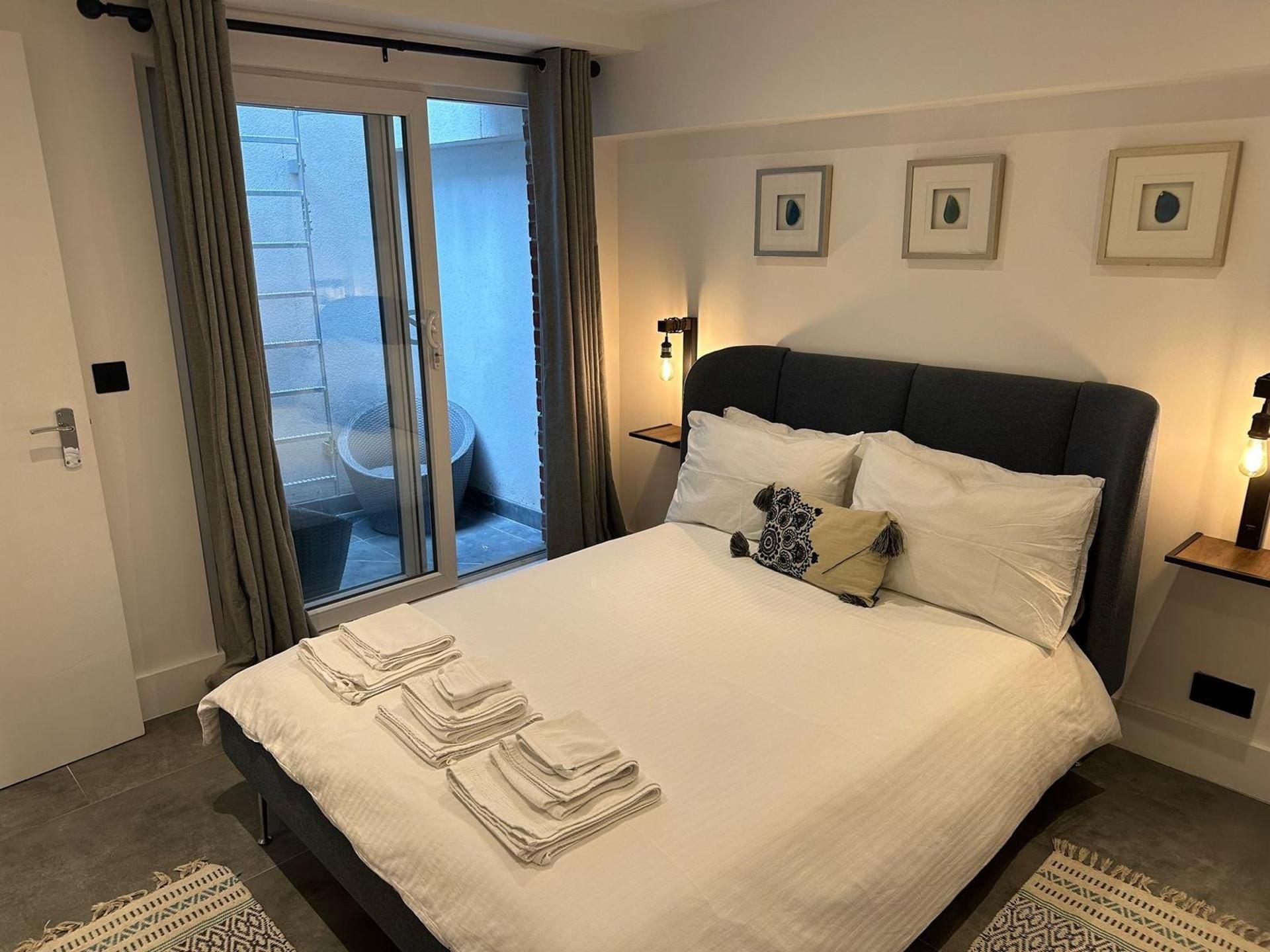 Une chambre d’hôtel avec un lit, un balcon et une vue sur l’extérieur.