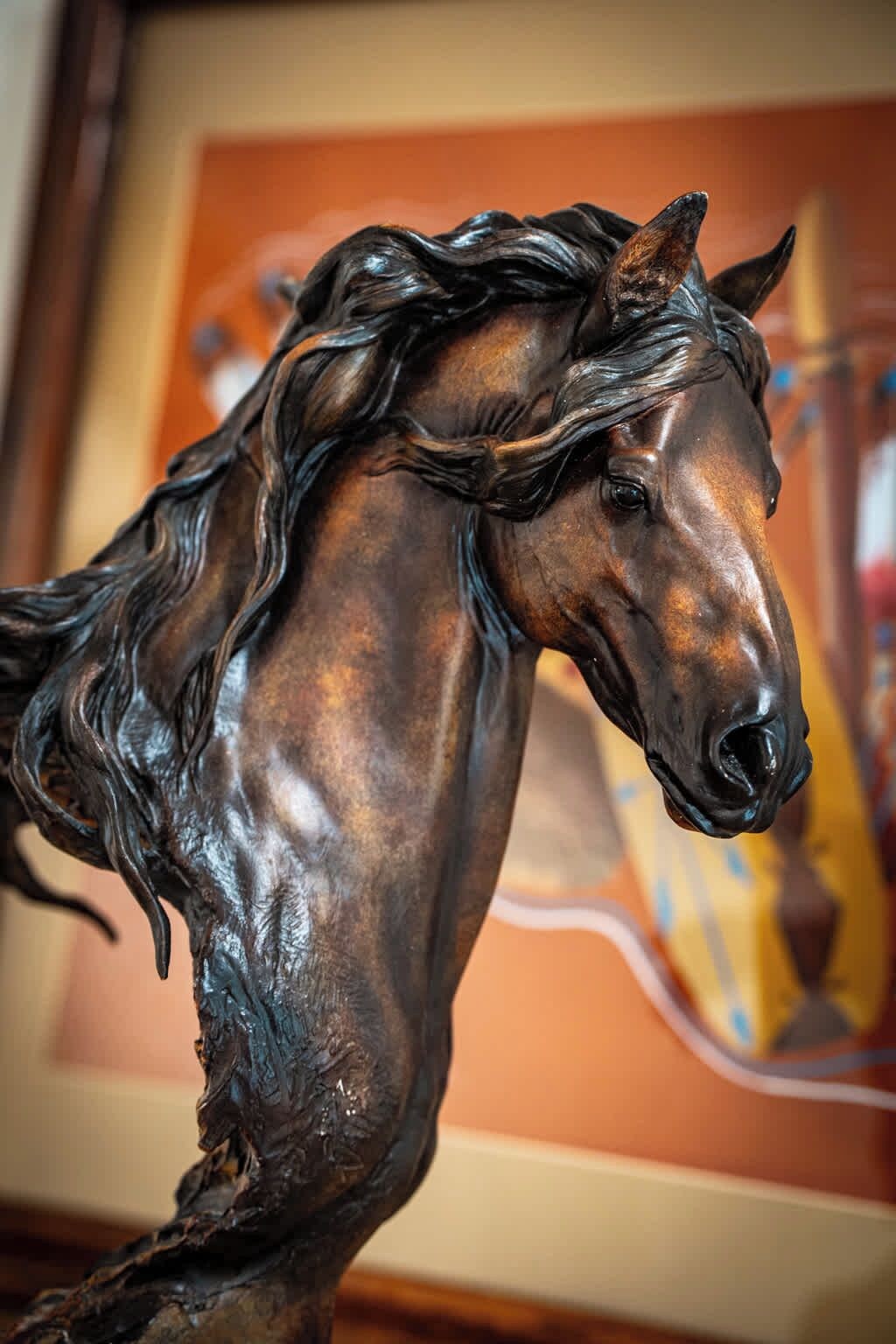 Escultura de bronze de um cavalo com crina e cabeça detalhadas.