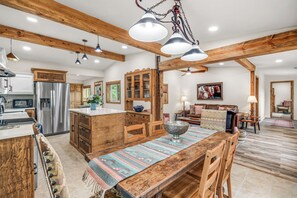 A spacious kitchen with a central island, wooden beams, and modern lighting fixtures. - Renovated Horse Corral Hideaway (Santa Fe)