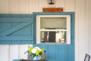 A building with a blue exterior, a window with a shutter, and a sign above the window that reads 'DIAMOND'. - Renovated Horse Corral Hideaway (Santa Fe)
