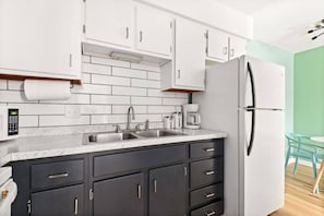 A modern kitchen with a double sink, a refrigerator, and a coffee maker. - The Lyric - #203 & #204 | Two Suites on Music Row (Nashville)