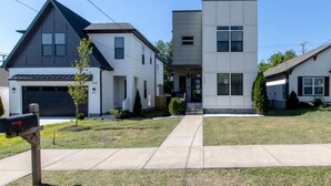 Une maison moderne à deux étages, dotée d’un garage, d’une cour avant et d’une boîte aux lettres.