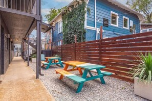 A covered outdoor area with picnic tables and a gravel path. - The Lyric - #201 & #202 | Two Suites on Music Row (Nashville)
