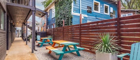 Eine Terrasse mit Picknicktischen und einem Holzzaun.