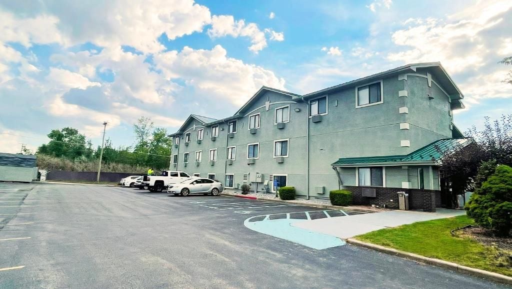 A multi-story building with a parking lot in front.