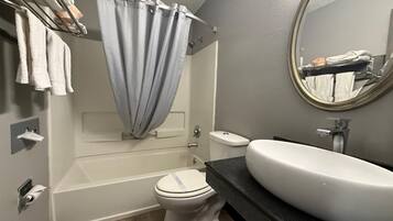 Une salle de bain avec une baignoire, des toilettes et un lavabo.