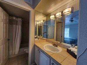 Un baño con lavamanos doble, un espejo grande y una zona de ducha.