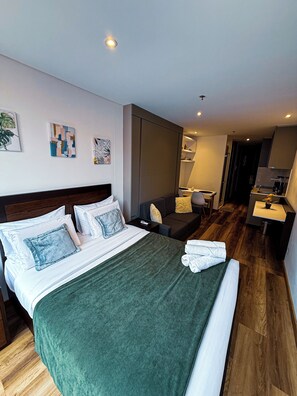 A hotel room with a bed, a sofa, a desk, and a bathroom. - Modern loft in TAJ 97, Chico, close to Parque de la 93 in Bogota (Bogotá, D.C.)