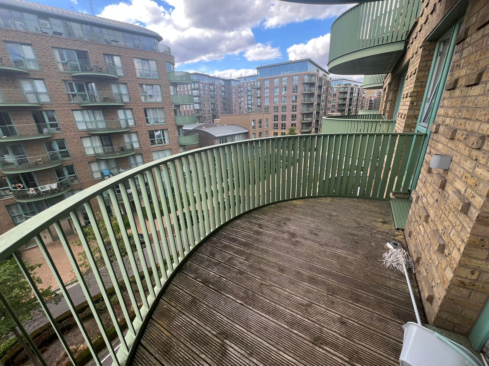 A curved balcony with a view of adjacent residential buildings.