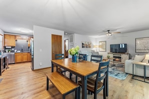 Un espacio habitable moderno con comedor, cocina y área de entretenimiento.