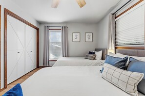 Un dormitorio con dos camas, un armario y una ventana con persianas.