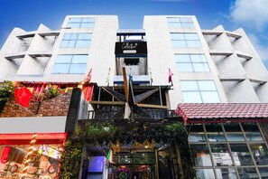 A modern building with a prominent sign at the entrance, a staircase leading to the entrance, and a view of the sky. - Super Collection O Circus Avenue Road (Kolkata)